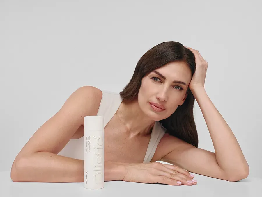 Mujer junto a The Shampoo Supreme Densifying de Olistic